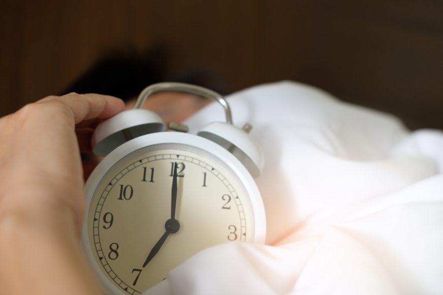 person's hand shutting off alarm clock