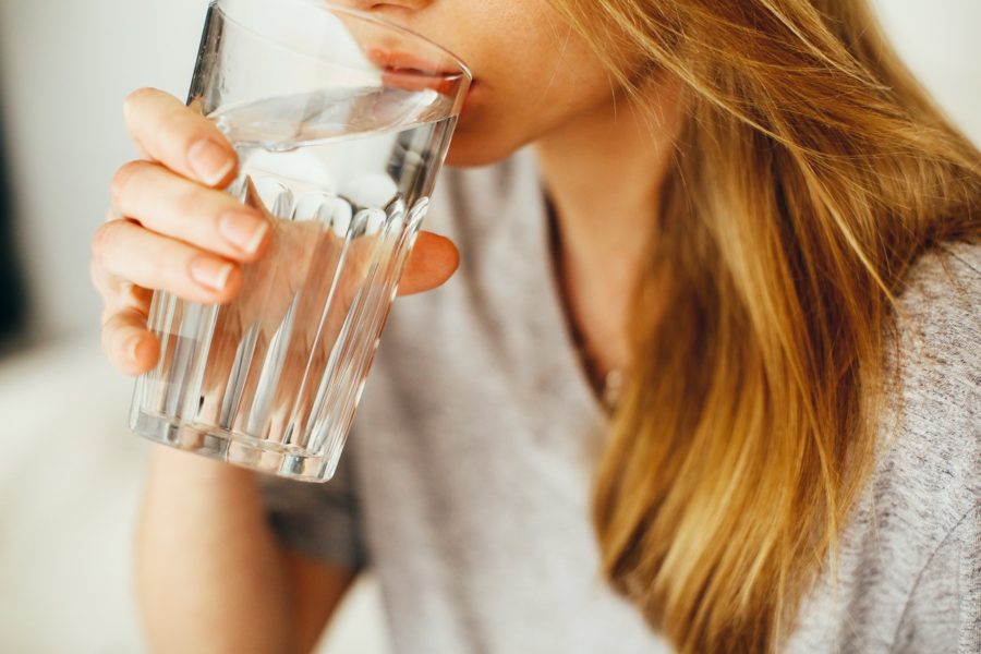 Young woman drinking glass of water in between meals.